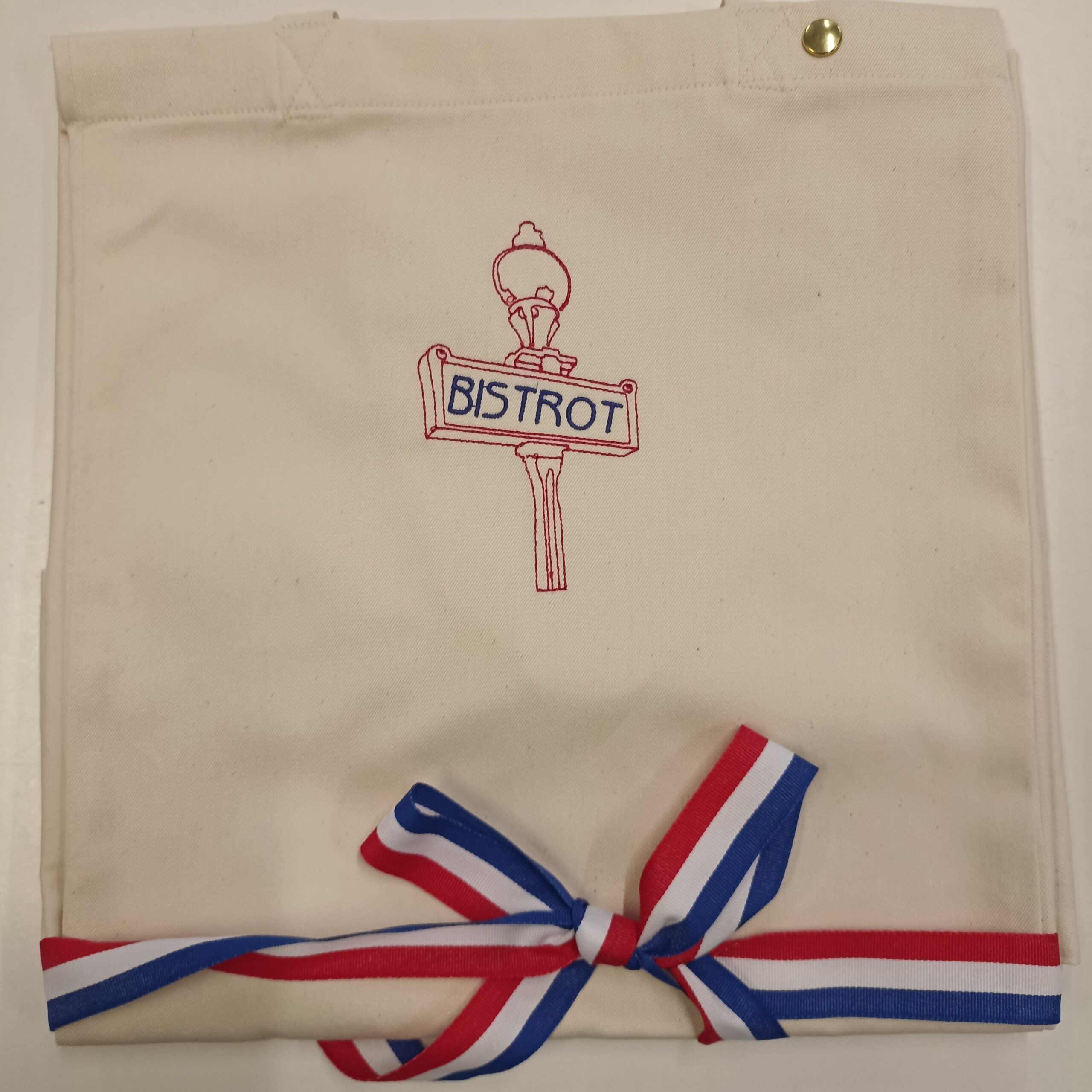 Tablier brodé « Bistrot » – Création de l’ESAT de la Bièvre Tablier en coton brodé « Bistrot » avec bande tricolore bleu-blanc-rouge.